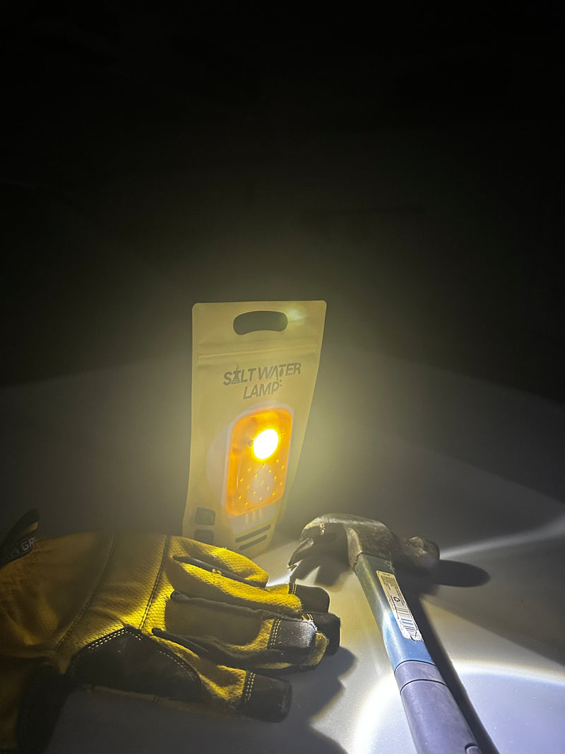 Salt Water Lamp glowing beside work gloves and tools during power outage